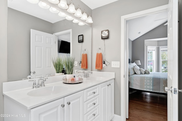 bathroom featuring vanity, wood-type flooring, and lofted ceiling