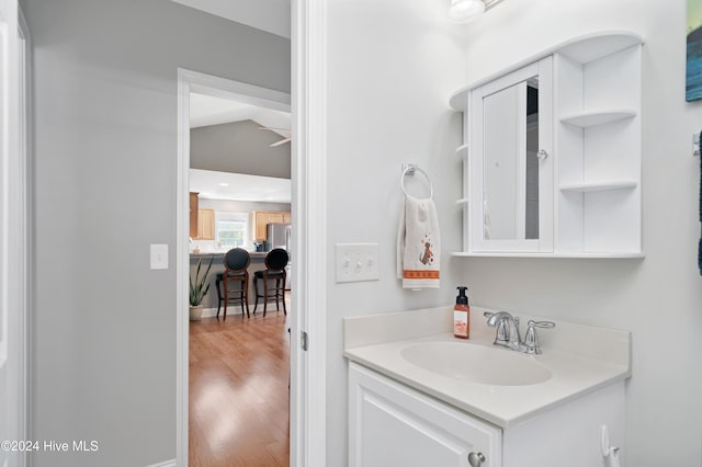 bathroom with vanity, wood-type flooring, and lofted ceiling