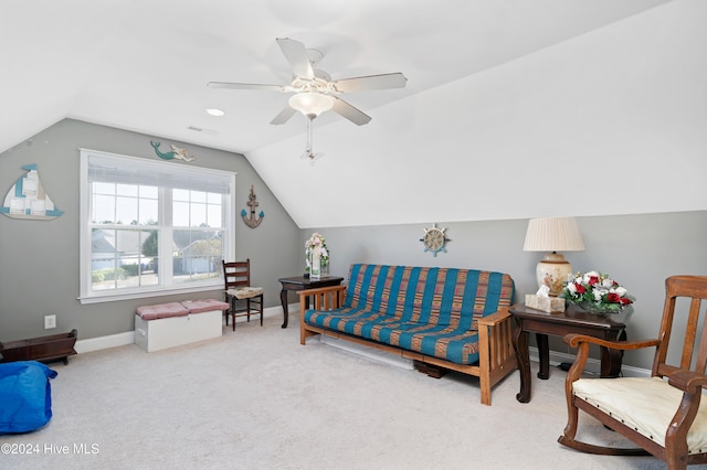 living area with ceiling fan, light colored carpet, and vaulted ceiling