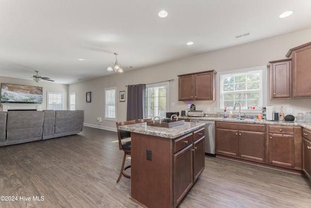 kitchen featuring stainless steel dishwasher, dark hardwood / wood-style floors, a healthy amount of sunlight, and a center island