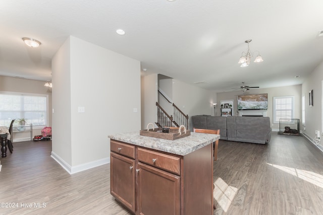 kitchen featuring light hardwood / wood-style floors, plenty of natural light, decorative light fixtures, and a center island