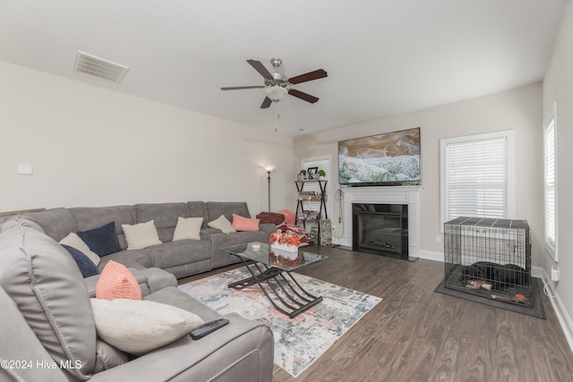 living room with dark hardwood / wood-style floors and ceiling fan