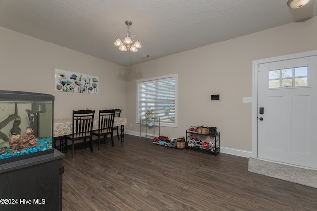 entrance foyer with dark hardwood / wood-style flooring, a chandelier, and a textured ceiling