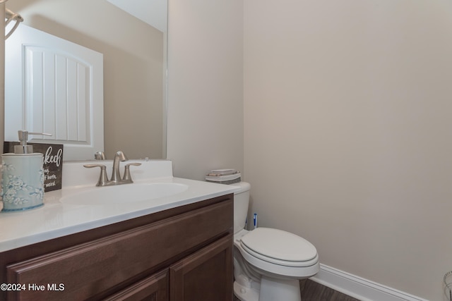 bathroom with vanity, hardwood / wood-style flooring, and toilet