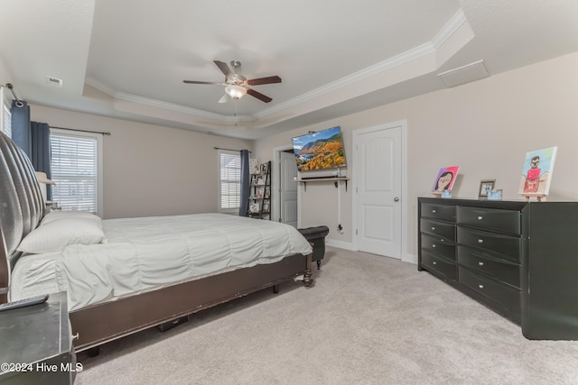 bedroom featuring crown molding, light colored carpet, ceiling fan, and a raised ceiling