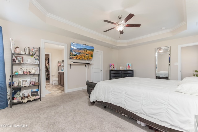 bedroom featuring a tray ceiling, light colored carpet, ceiling fan, and crown molding