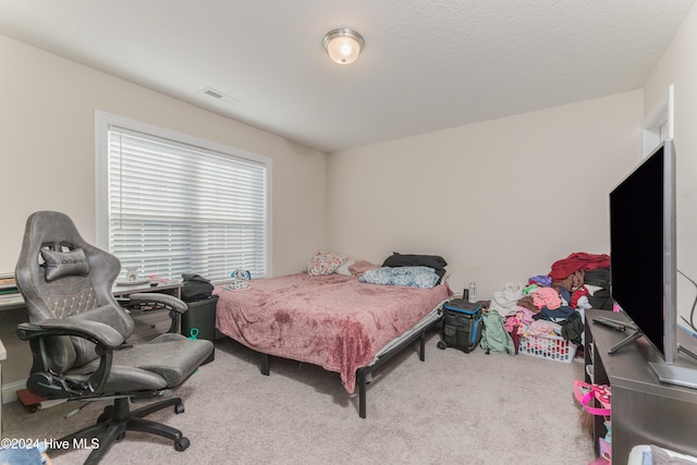 carpeted bedroom featuring a textured ceiling