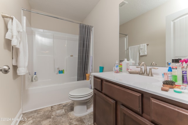 full bathroom with a textured ceiling, vanity, shower / bath combo with shower curtain, and toilet