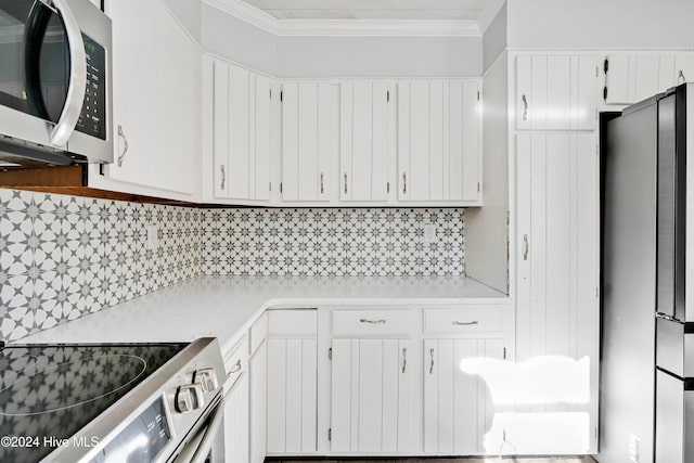 kitchen with crown molding, white cabinets, and appliances with stainless steel finishes