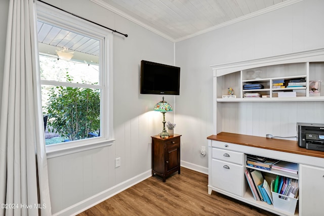 office space with a wealth of natural light, hardwood / wood-style floors, crown molding, and wood walls