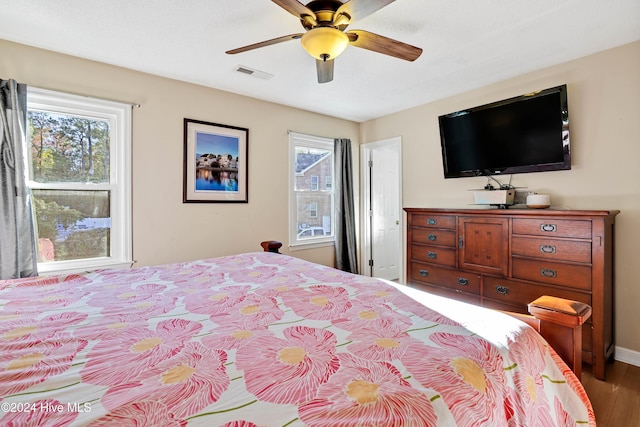 bedroom featuring wood-type flooring, multiple windows, and ceiling fan