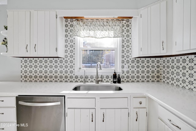 kitchen featuring tasteful backsplash, white cabinetry, dishwasher, and sink