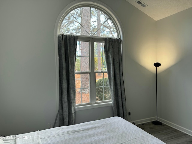 bedroom with dark hardwood / wood-style flooring and a textured ceiling