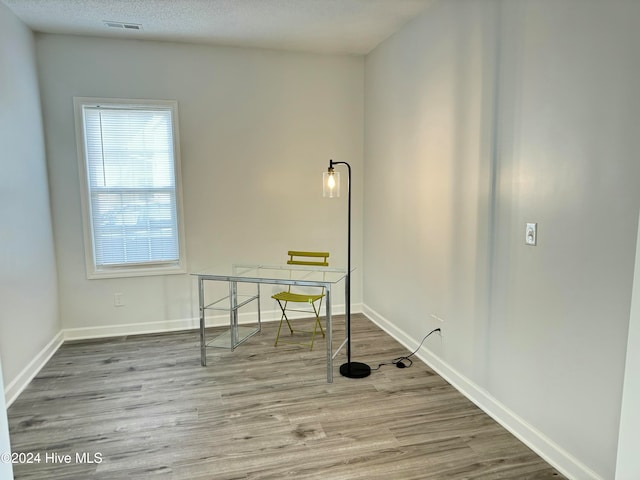 laundry area with hardwood / wood-style flooring and a textured ceiling