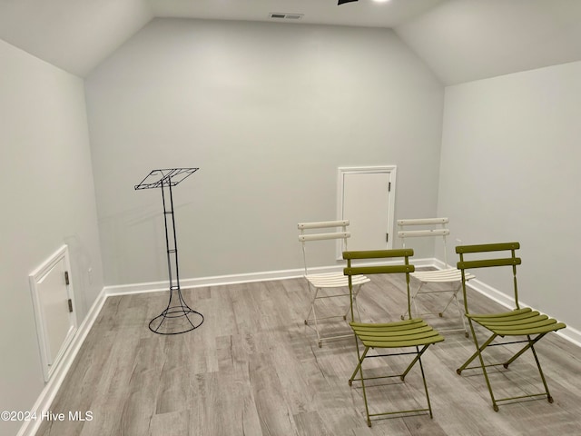 unfurnished room with light wood-type flooring and lofted ceiling