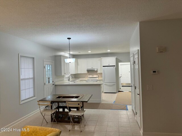 tiled dining room featuring a textured ceiling and sink