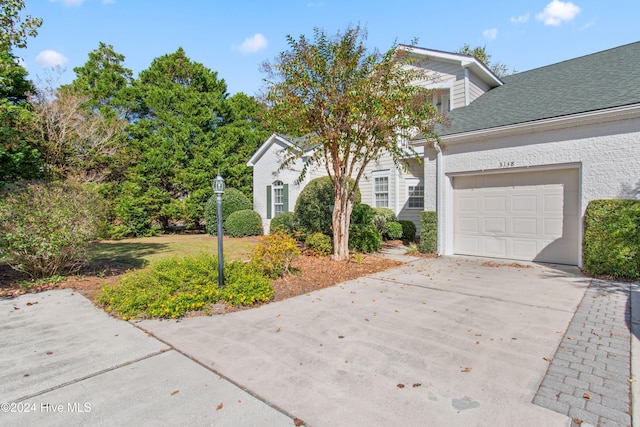 view of front of house with a shingled roof, driveway, and an attached garage