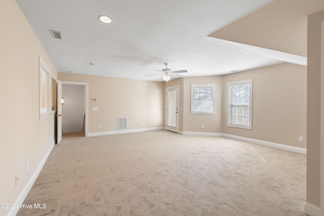 spare room featuring visible vents, light carpet, and baseboards