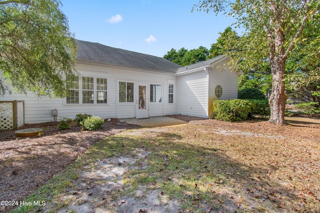 rear view of property with roof with shingles and a patio