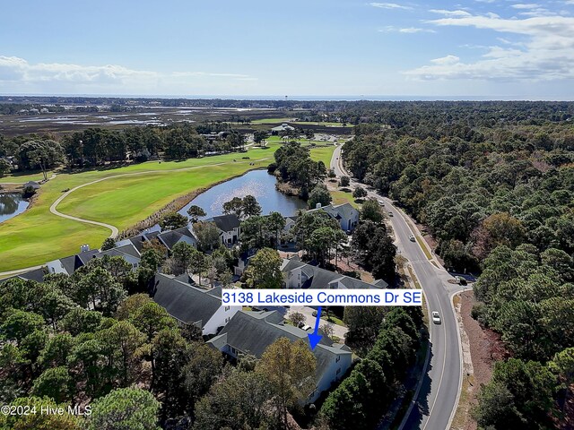 drone / aerial view with a water view and golf course view