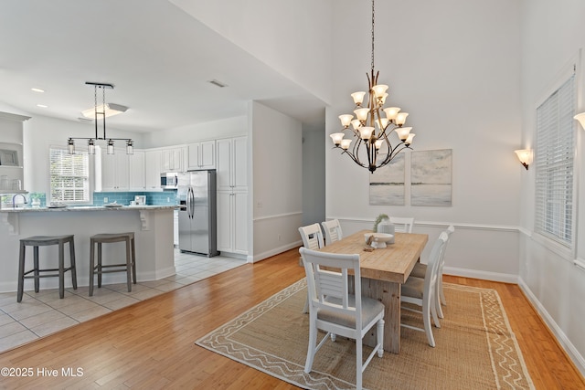 dining room featuring visible vents, a notable chandelier, light wood-style flooring, and baseboards