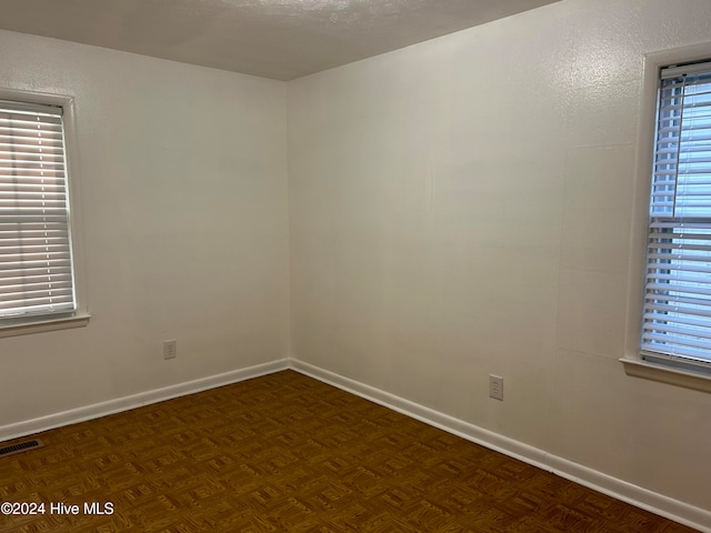 spare room with dark parquet floors