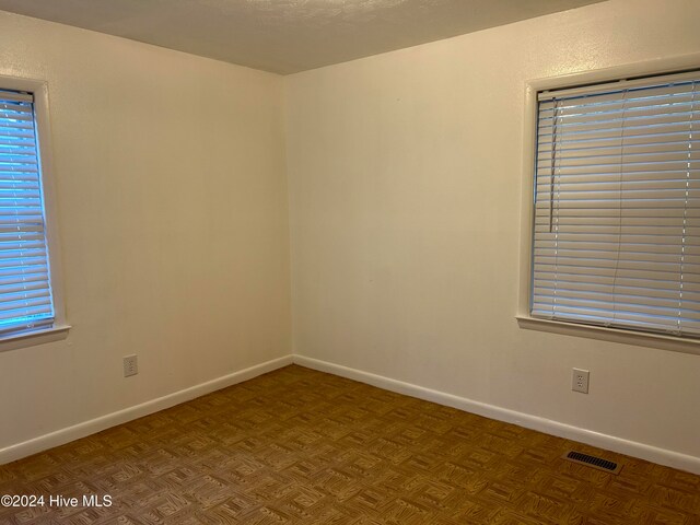 spare room featuring parquet flooring