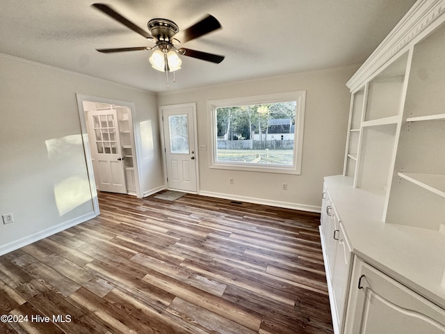 unfurnished dining area with ceiling fan, dark hardwood / wood-style flooring, and crown molding