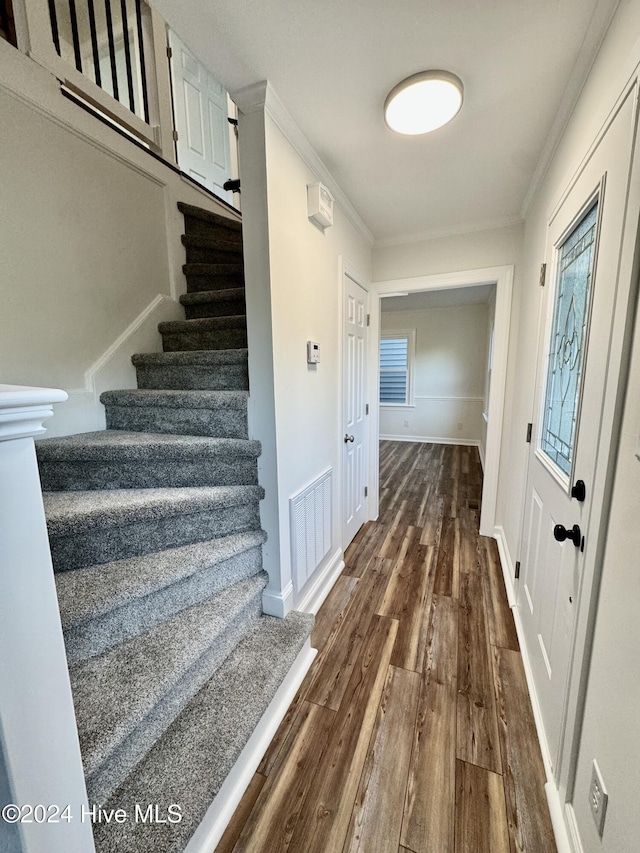 staircase featuring hardwood / wood-style flooring and ornamental molding