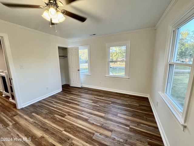 unfurnished bedroom with ceiling fan, a closet, dark hardwood / wood-style floors, and ornamental molding