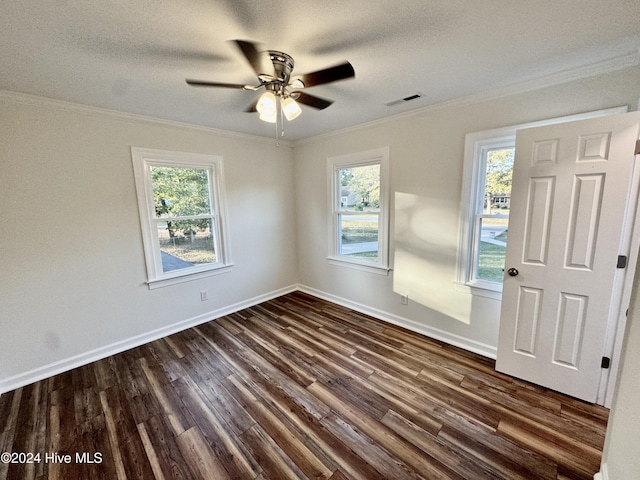 unfurnished room featuring dark hardwood / wood-style floors, ornamental molding, and a wealth of natural light