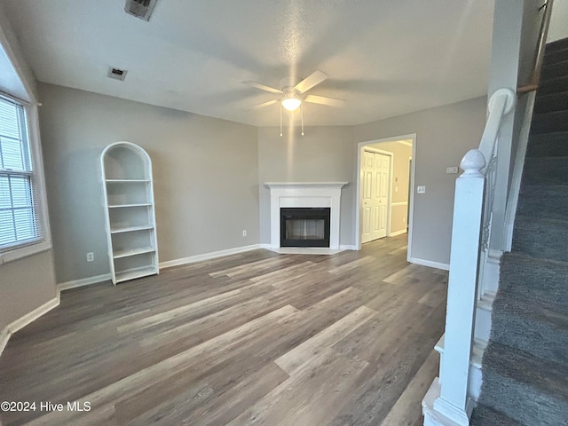 unfurnished living room featuring hardwood / wood-style floors and ceiling fan