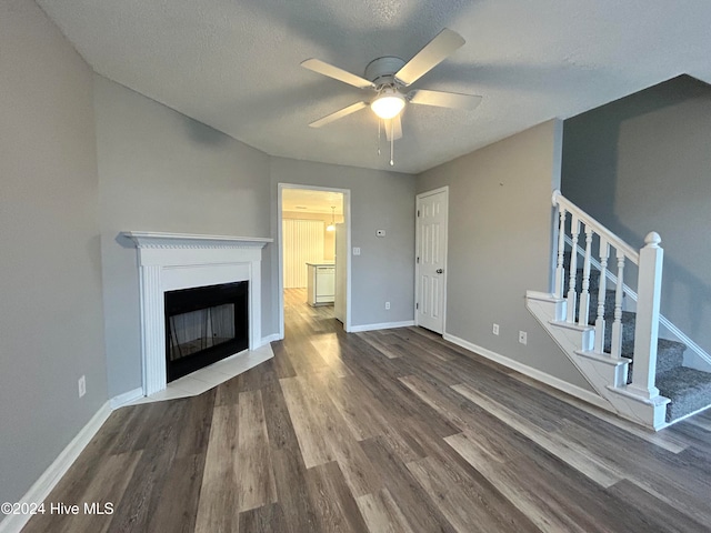 unfurnished living room featuring a textured ceiling, wood-type flooring, and ceiling fan