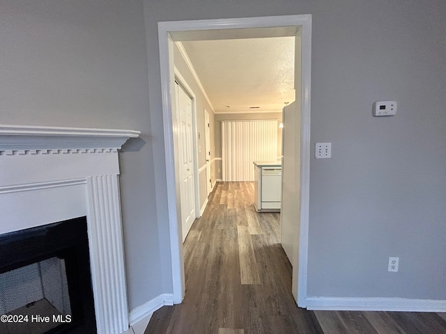 corridor with hardwood / wood-style flooring and a textured ceiling