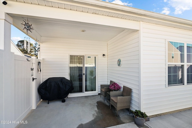 view of patio with fence and a grill