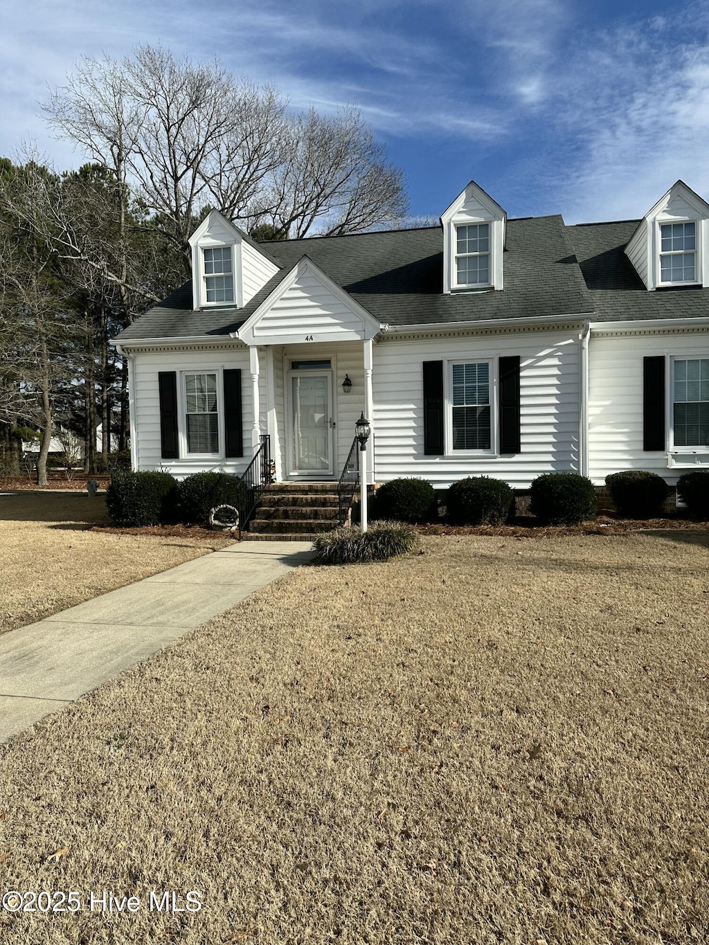 cape cod-style house with a front lawn