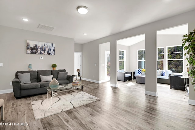 living room featuring vaulted ceiling and light hardwood / wood-style floors