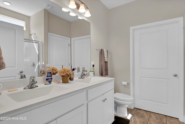 bathroom featuring vanity, toilet, tile patterned floors, and an enclosed shower