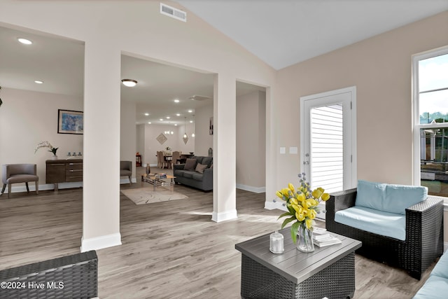 living room featuring lofted ceiling and light hardwood / wood-style floors