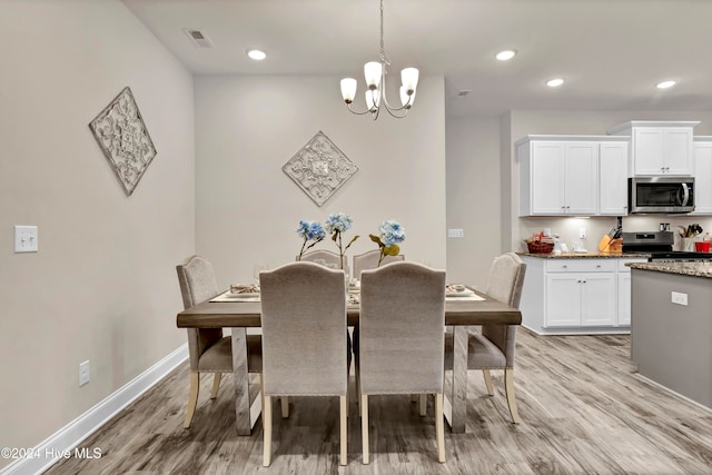 dining area featuring light hardwood / wood-style flooring and a notable chandelier