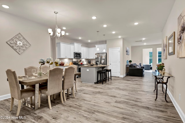 dining area featuring light hardwood / wood-style floors and a notable chandelier