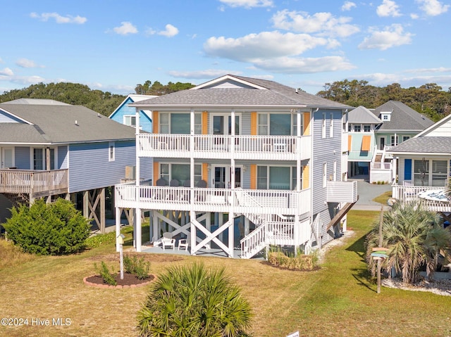 rear view of house with a yard and a balcony