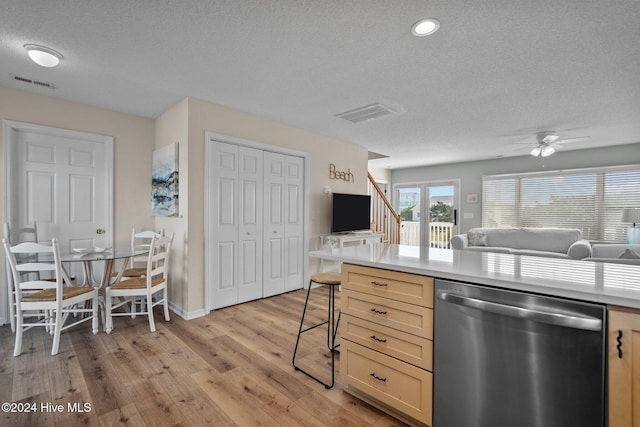 kitchen featuring ceiling fan, a textured ceiling, light brown cabinetry, light wood-type flooring, and dishwasher