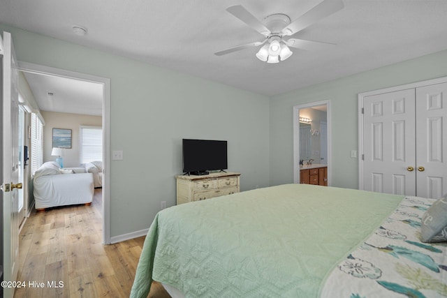 bedroom with a closet, ceiling fan, light wood-type flooring, and ensuite bath