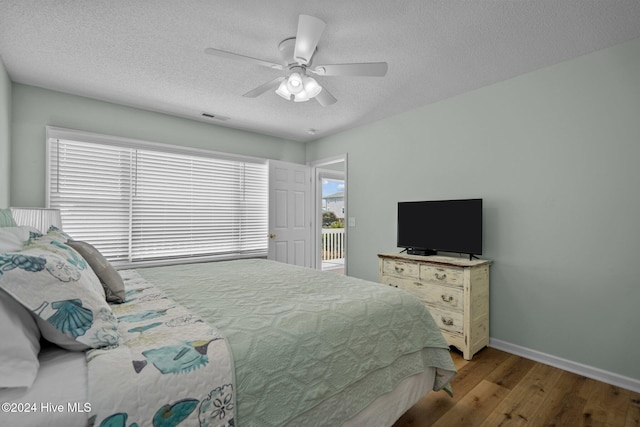 bedroom featuring a textured ceiling, light wood-type flooring, and ceiling fan