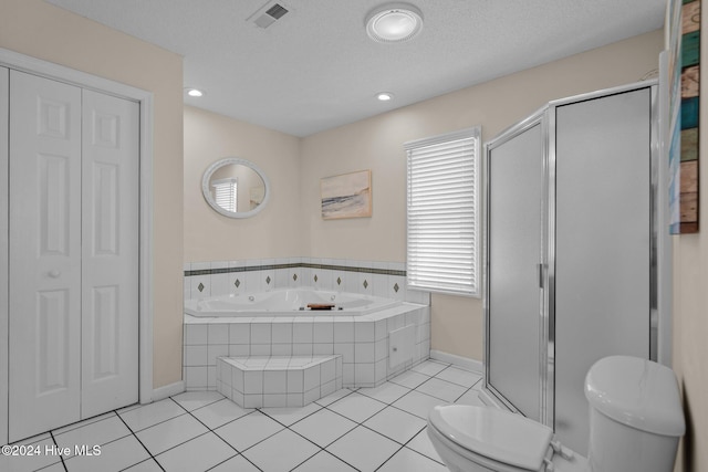 bathroom with toilet, tile patterned floors, a textured ceiling, and separate shower and tub