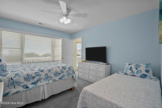 carpeted bedroom with a textured ceiling and ceiling fan