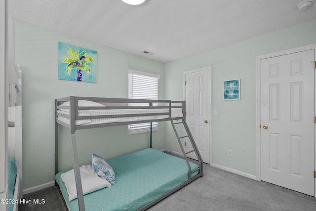 bedroom with carpet floors and a textured ceiling