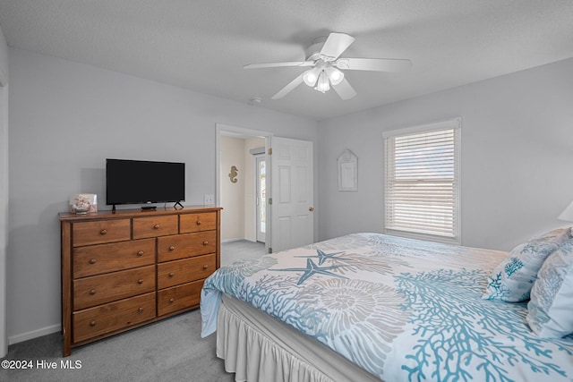 carpeted bedroom featuring a textured ceiling and ceiling fan