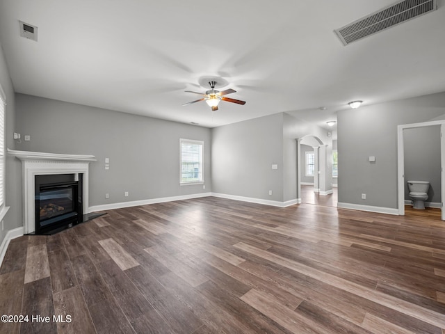 unfurnished living room featuring ceiling fan, wood-type flooring, and plenty of natural light